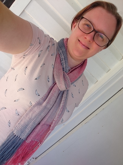 Profile Image - Emily
A smiling woman with light skin wearing a pink top and a blue, grey & pink scarf. She is also wearing glasses and has her hair tied back.